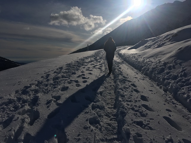 Photo of a woman walking in snow on a mountain in Italy